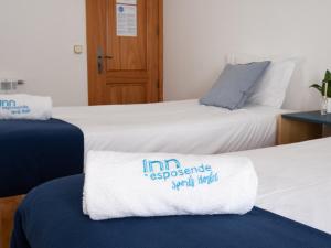 two beds in a room with a towel on the bed at InnEsposende Sports Hostel in Esposende