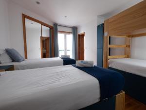 a bedroom with three beds and a bunk bed at InnEsposende Sports Hostel in Esposende