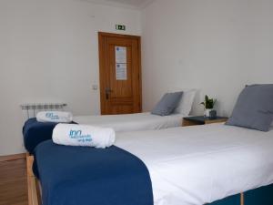 two beds with towels on them in a room at InnEsposende Sports Hostel in Esposende