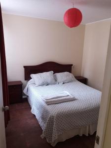 1 dormitorio con 1 cama y lámpara roja en Departamento Mar, en La Serena