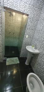 y baño con aseo, lavabo y espejo. en Adonai Copacabana Rooms 01, en Río de Janeiro