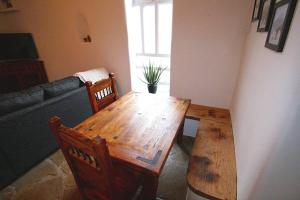 una mesa de madera y sillas en la sala de estar. en Closson Casita - Patio & Fire Pit - Near Plaza - 1BR, en Santa Fe