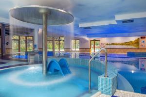 une grande piscine intérieure avec une grande piscine dans l'établissement Hotel Verde Montana Wellness & Spa, à Kudowa-Zdrój