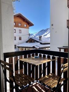 un banc en bois installé au-dessus d'un balcon dans l'établissement Central Apart Chalet, à Breuil-Cervinia