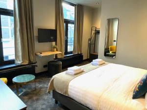 een slaapkamer met een groot bed en een spiegel bij Hotel de Prince in Nijmegen