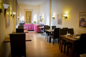 un restaurant avec des tables et des chaises et un comptoir rose dans l'établissement Hotel am Landeshaus, à Wiesbaden