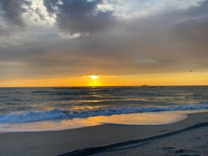 a sunset on a beach with the ocean at Pelican Hotel in Miami Beach