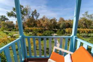 uma varanda com cadeiras laranja e vista para um parque em Yonca Lodge em Fethiye