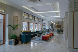 eine Lobby mit Sofas und Stühlen in einem Gebäude in der Unterkunft Hotel Savoy Homann in Bandung