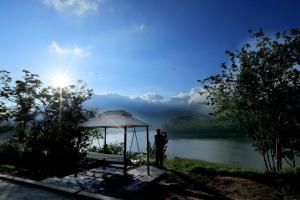 Un uomo in piedi accanto a un gazebo vicino a un lago di Ottway Hills Near Mattupetty Dam a Munnar