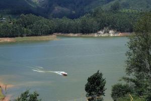 Una barca in mezzo a un lago di Ottway Hills Near Mattupetty Dam a Munnar