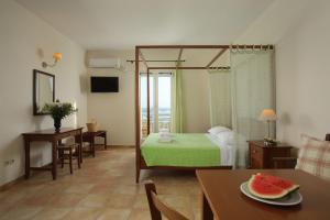 une chambre avec un lit et une table avec une plaque de pastèque dans l'établissement Aeolos Hotel, à Koufonisia