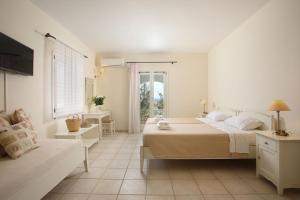 - une chambre blanche avec 2 lits et un canapé dans l'établissement Aeolos Hotel, à Koufonisia