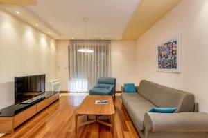 uma sala de estar com um sofá e uma televisão em Apartments Athos em Podgorica