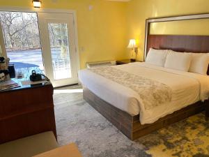 Habitación de hotel con cama grande y ventana en Cascades Inn, en Bloomington