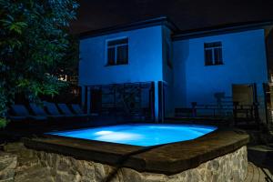 a swimming pool in front of a house at night at Dniprovskiy Dvir in Dnipro