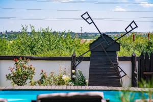 a garden with a black windmill on a fence at Dniprovskiy Dvir in Dnipro