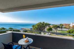 einen Balkon mit einem Tisch und Meerblick in der Unterkunft Hotel Plaža in Omiš