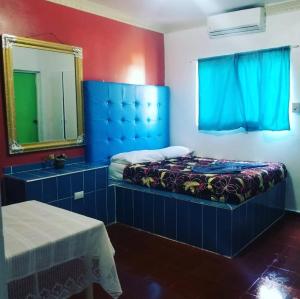 Schlafzimmer mit einem Bett, einem Spiegel und einem Spiegel in der Unterkunft Hotel Kevin in San Felipe de Puerto Plata