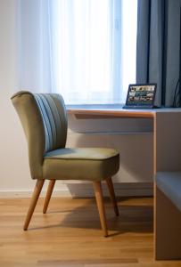 a chair sitting in front of a desk with a laptop at Le Baldinger Boutique Hotel in Bamberg