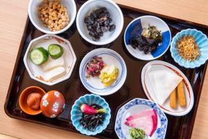 a tray filled with different types of food in bowls at Dormy Inn Premium Kyoto Ekimae Natural Hot Spring in Kyoto