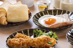 a table topped with plates of food with eggs and bread at Dormy Inn Premium Kyoto Ekimae Natural Hot Spring in Kyoto