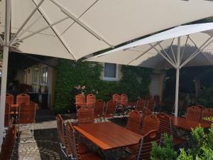 a wooden table and chairs under an umbrella at Landgasthof Hotel Rittmayer in Hallerndorf