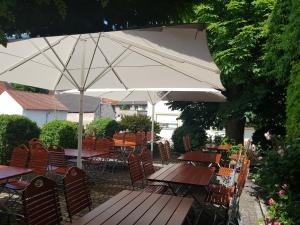 a patio with tables and chairs and an umbrella at Landgasthof Hotel Rittmayer in Hallerndorf