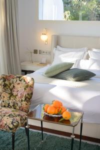 1 dormitorio con 1 cama con silla y bandeja de naranjas en Maison Dedine- SmallLuxuryHotels -Adults Only, en Sidi Bou Saïd