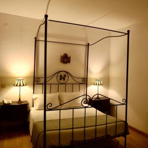 a bedroom with a metal canopy bed with two lamps at Hotel Portofoz in Porto