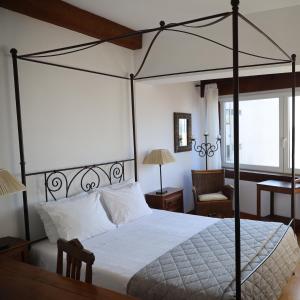 a bedroom with a canopy bed and a chair at Hotel Portofoz in Porto