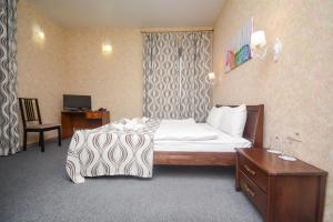 una camera d'albergo con letto e scrivania di Три Сімки a Vyšhorod