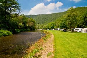 een rivier naast een camping met een berg bij Chalet Gringlee in Goebelsmuhle