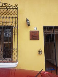 a yellow wall with a sign on the side of a building at Hotel Vista al Cerro in Antigua Guatemala