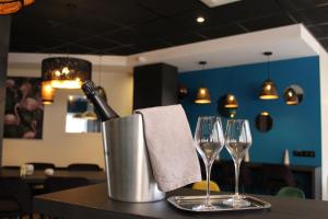 a table with a bottle of wine and two wine glasses at Hotel de Champagne in Épernay