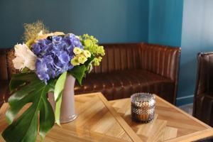 a vase filled with purple and yellow flowers on a table at Hotel de Champagne in Épernay