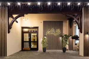 an entrance to a store with a door and two plants at NeboS Hotel & Restaurant in Ivano-Frankivsʼk