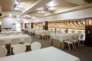 a large room with tables and white chairs at NeboS Hotel & Restaurant in Ivano-Frankivsʼk