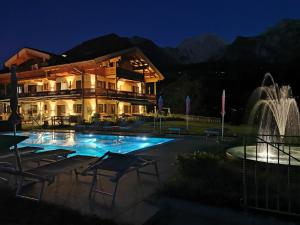 una casa con una fontana di fronte a un edificio di Gästehaus Obersulzberglehen a Schönau am Königssee