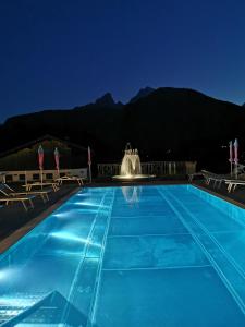 una piscina notturna con fontana di Gästehaus Obersulzberglehen a Schönau am Königssee