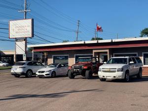 a truck and cars parked in front of a store at Stonehouse Motel and Restaurant in Truro