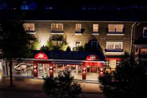 - un bâtiment avec un restaurant en face de lui la nuit dans l'établissement Hotel Willinger Mitte, à Willingen