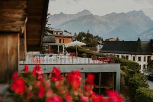 einen Blick auf ein Gebäude mit roten Blumen im Vordergrund in der Unterkunft Les Mazots du Clos in Villars-sur-Ollon