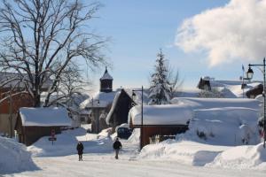 Une rue enneigée avec des gens qui marchent dans la neige dans l'établissement Chalet Hotel Le Mont Bisanne, à Crest-Voland