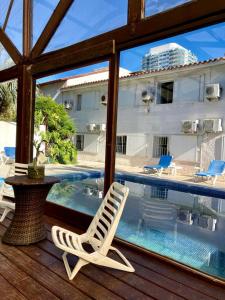 un par de sillas sentadas en una terraza junto a una piscina en Hotel Oasis, en Punta del Este