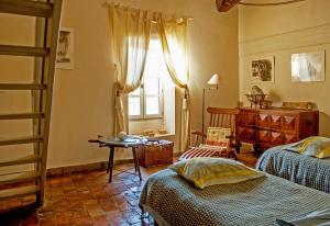 1 dormitorio con 2 camas y ventana en Demeure de Digoine "Chambre d'Hotes", en Bourg-Saint-Andéol