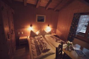 a bedroom with a bed and two tables and a window at Pension Sonne in Adelboden