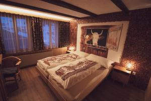 a bedroom with a bed with a picture of a cow on the wall at Pension Sonne in Adelboden