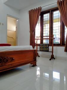 ein Schlafzimmer mit einem Bett und zwei Fenstern in der Unterkunft Prayogo Lama Prawirotaman in Yogyakarta