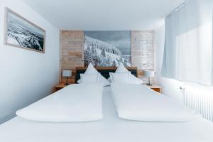 a bedroom with two beds with white sheets at Black Forest Dream Apartments in Feldberg